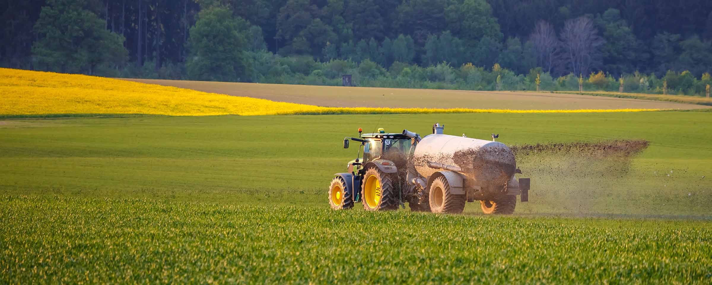Tractor spraying crops in rural field